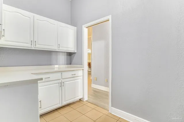 a kitchen with white cabinets and a refrigerator
