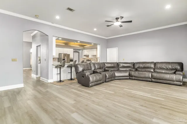 a living room with couches and a view of kitchen