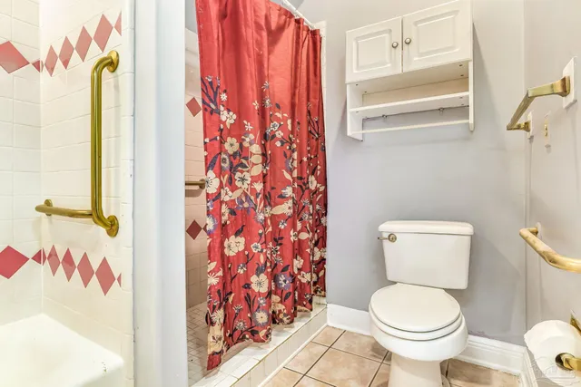 a white toilet sitting next to a shower curtain