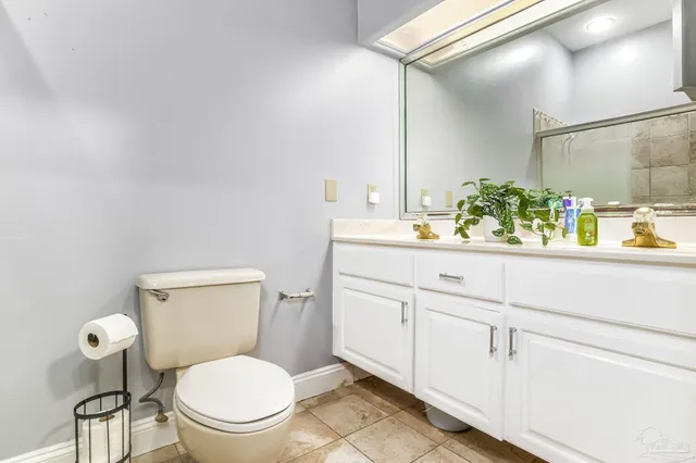 a bathroom with a toilet sink vanity and mirror