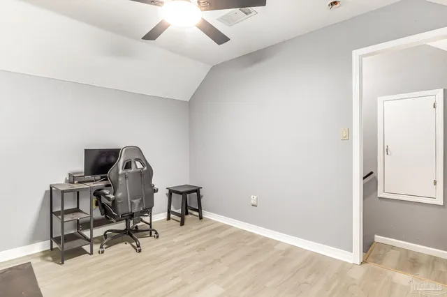 a view of a workspace with furniture and a window