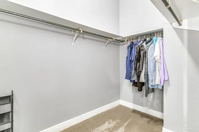 a view of walk in closet with clothes