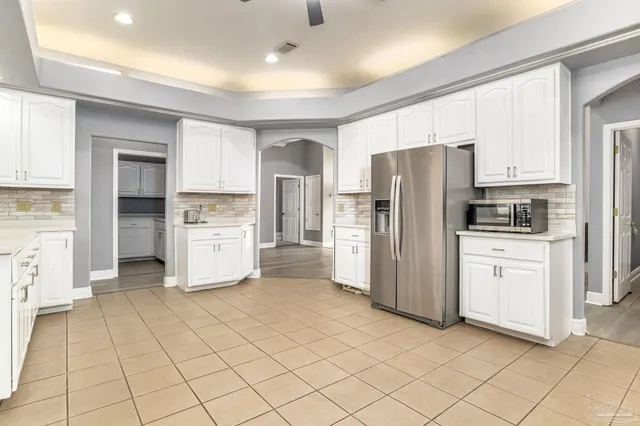 a kitchen with white cabinets and stainless steel appliances