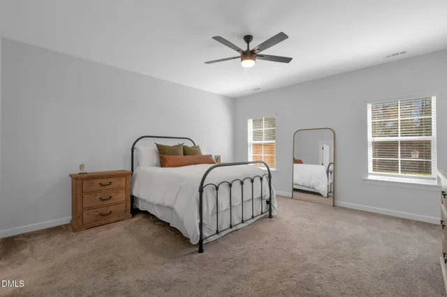 a bedroom with a bed a chandelier and dresser