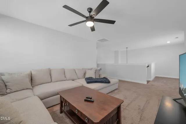 a living room with furniture and a ceiling fan