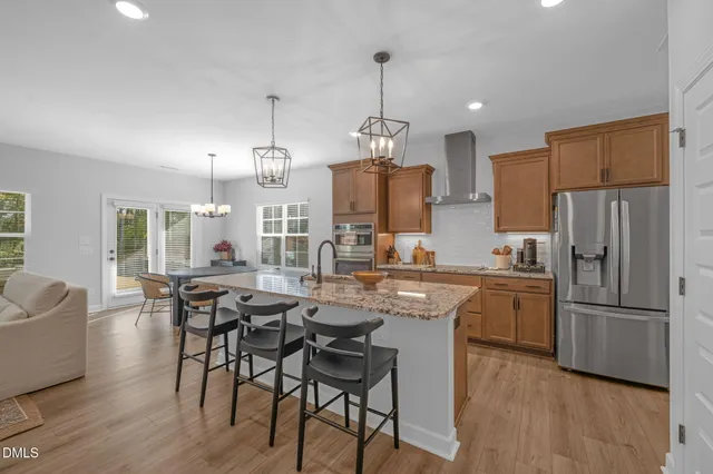 a kitchen with refrigerator a sink and chairs