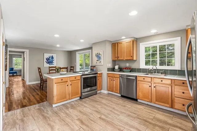 a large kitchen with stainless steel appliances granite countertop a stove and a sink