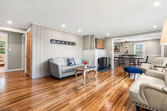 a living room with fireplace furniture and a wooden floor