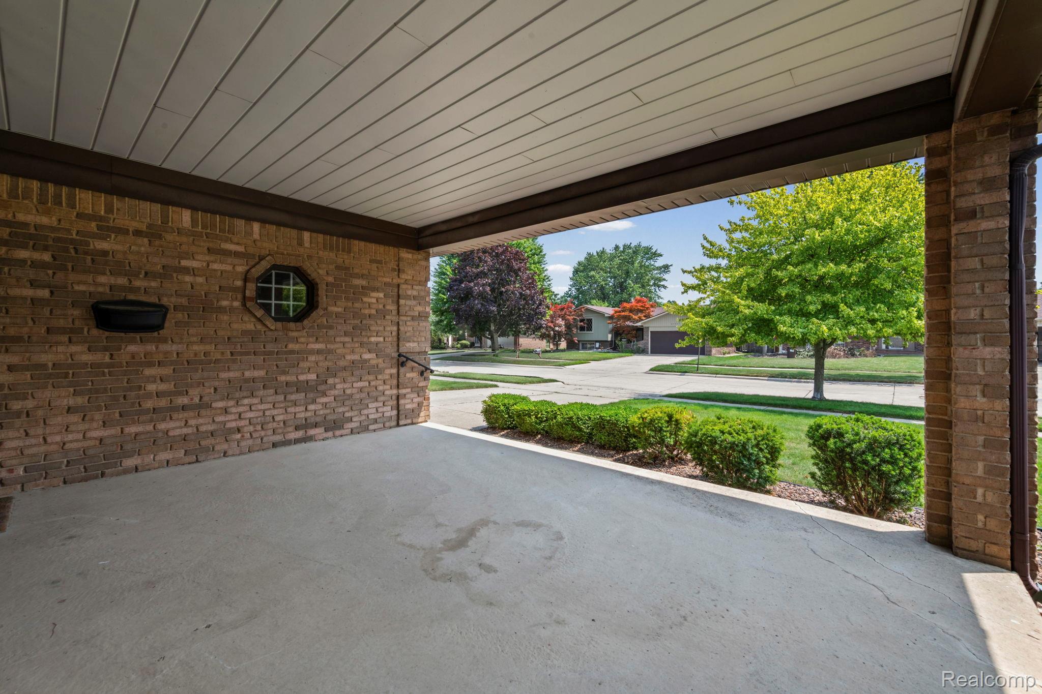 21580 Georgetown Road Trenton, MI 48183 - Photo 30 of 36 Covered concrete patio featuring a brick exterior wall, octagonal accent window, and beadboard ceiling