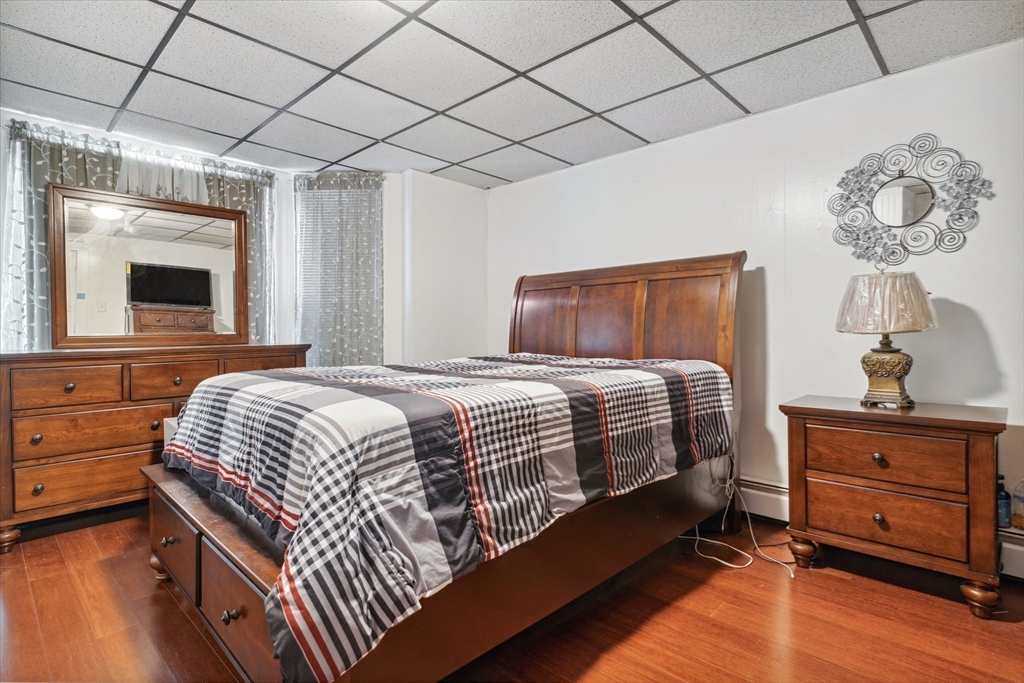 100 Bailey Street, Unit 3 Lawrence, MA 01843 - Photo 11 of 13 a bedroom with a bed and a chandelier