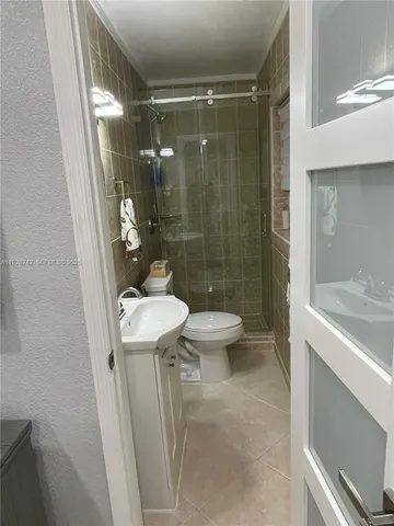 a bathroom with a shower a toilet and sink