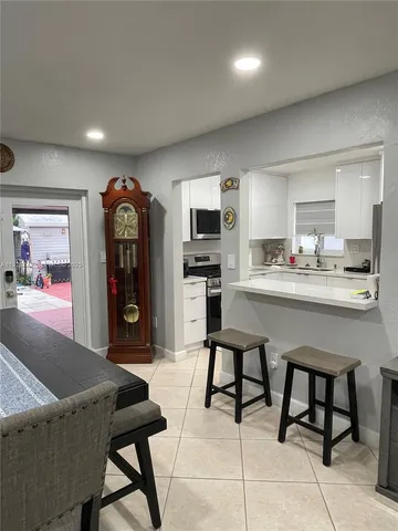 a living room with stainless steel appliances kitchen island granite countertop furniture and a view of kitchen
