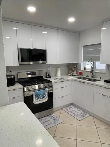 a kitchen with a sink a stove and cabinets
