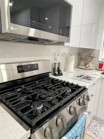 a stove sitting inside of a kitchen with white cabinets