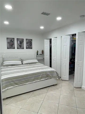 a living room with stainless steel appliances furniture a rug and a refrigerator