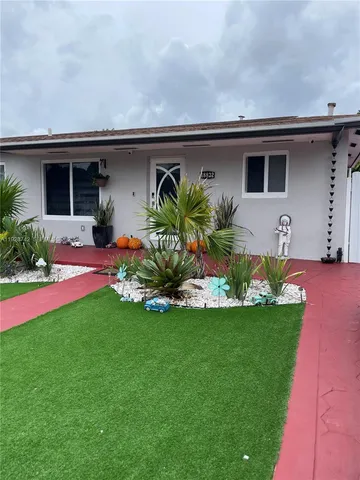 a front view of a house with a garden and plants