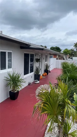 a view of a house with porch and garden
