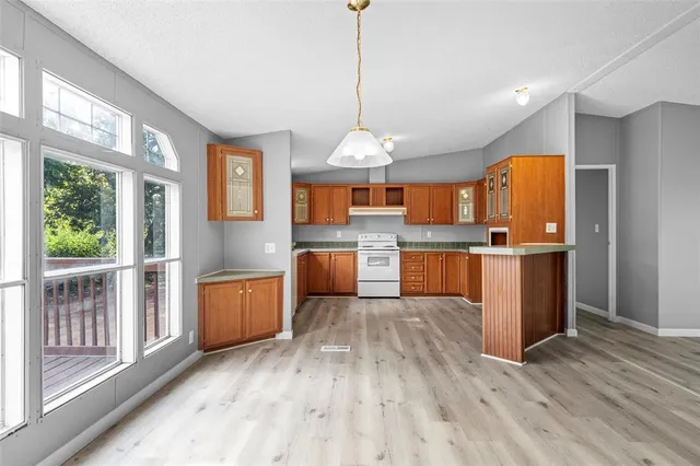 a large kitchen with cabinets wooden floor and stainless steel appliances