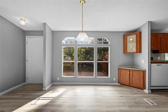 a view of an empty room with window and cabinet