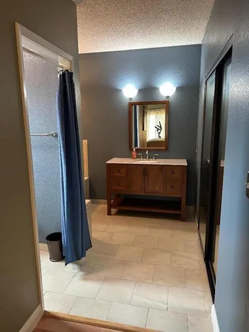a bathroom with a granite countertop sink and a mirror