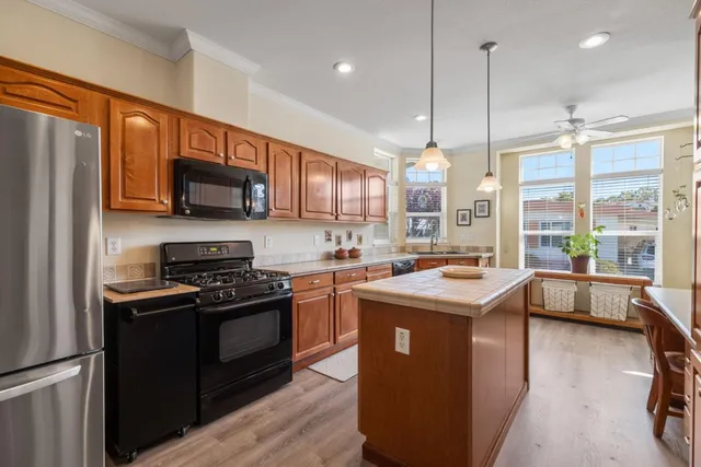 a kitchen with stainless steel appliances granite countertop a stove a sink a refrigerator and a microwave