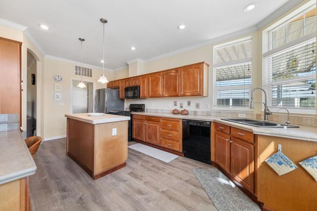 a kitchen with stainless steel appliances granite countertop a stove a sink dishwasher and a refrigerator