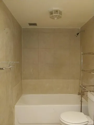 a bathroom with a toilet and a bath tub