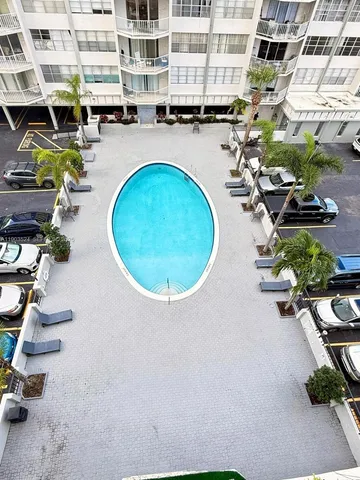 an aerial view of a swimming pool with outdoor seating