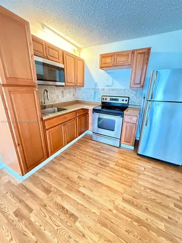 a kitchen with granite countertop stainless steel appliances and wooden cabinets
