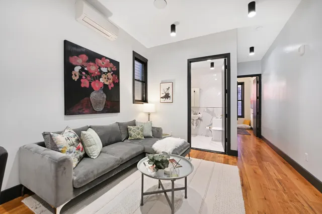 a living room with furniture a flat screen tv and a wall painting