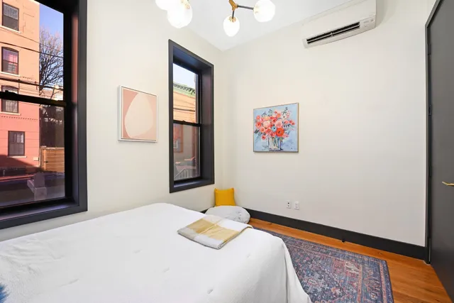 a bedroom with a bed and a painting on the wall