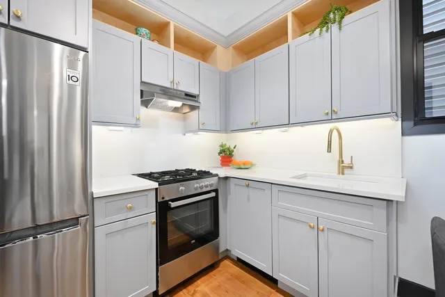 a kitchen with stainless steel appliances granite countertop a refrigerator sink and stove