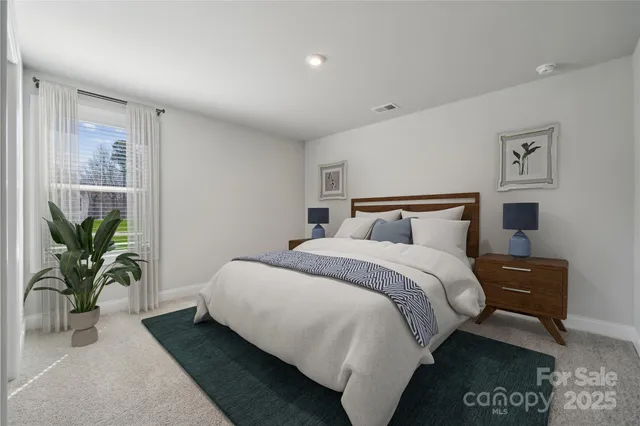 a bedroom with bed and a potted plant