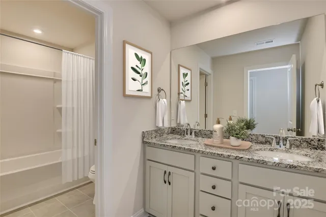 a bathroom with double sink and a mirror