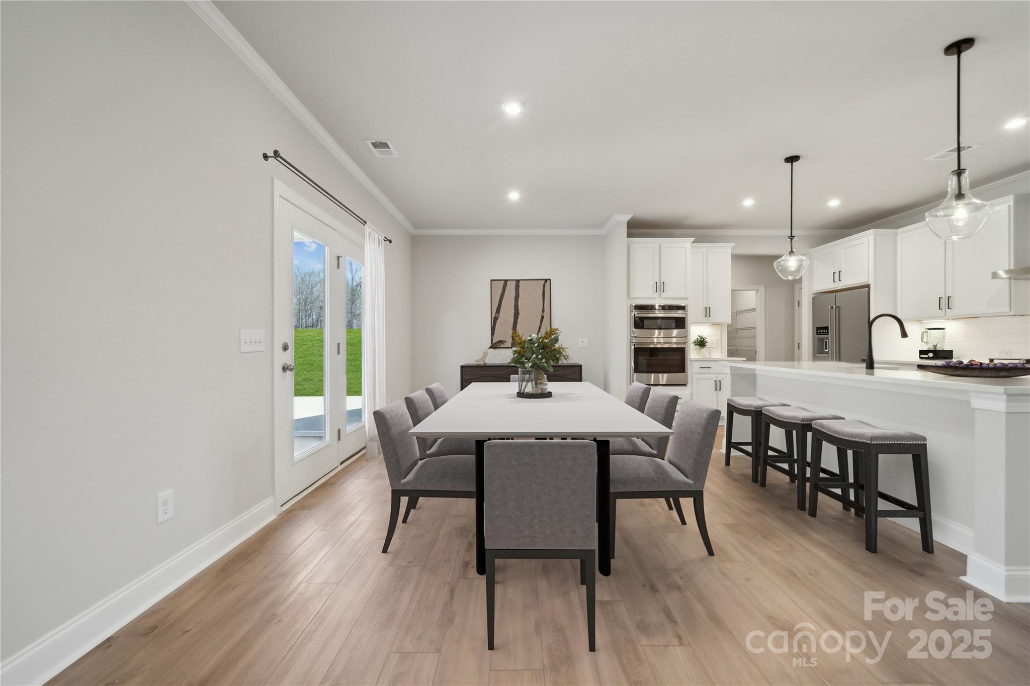327 Alameda Way Matthews, NC 28104 - Photo 8 of 31 a kitchen with a dining table chairs and wooden floor