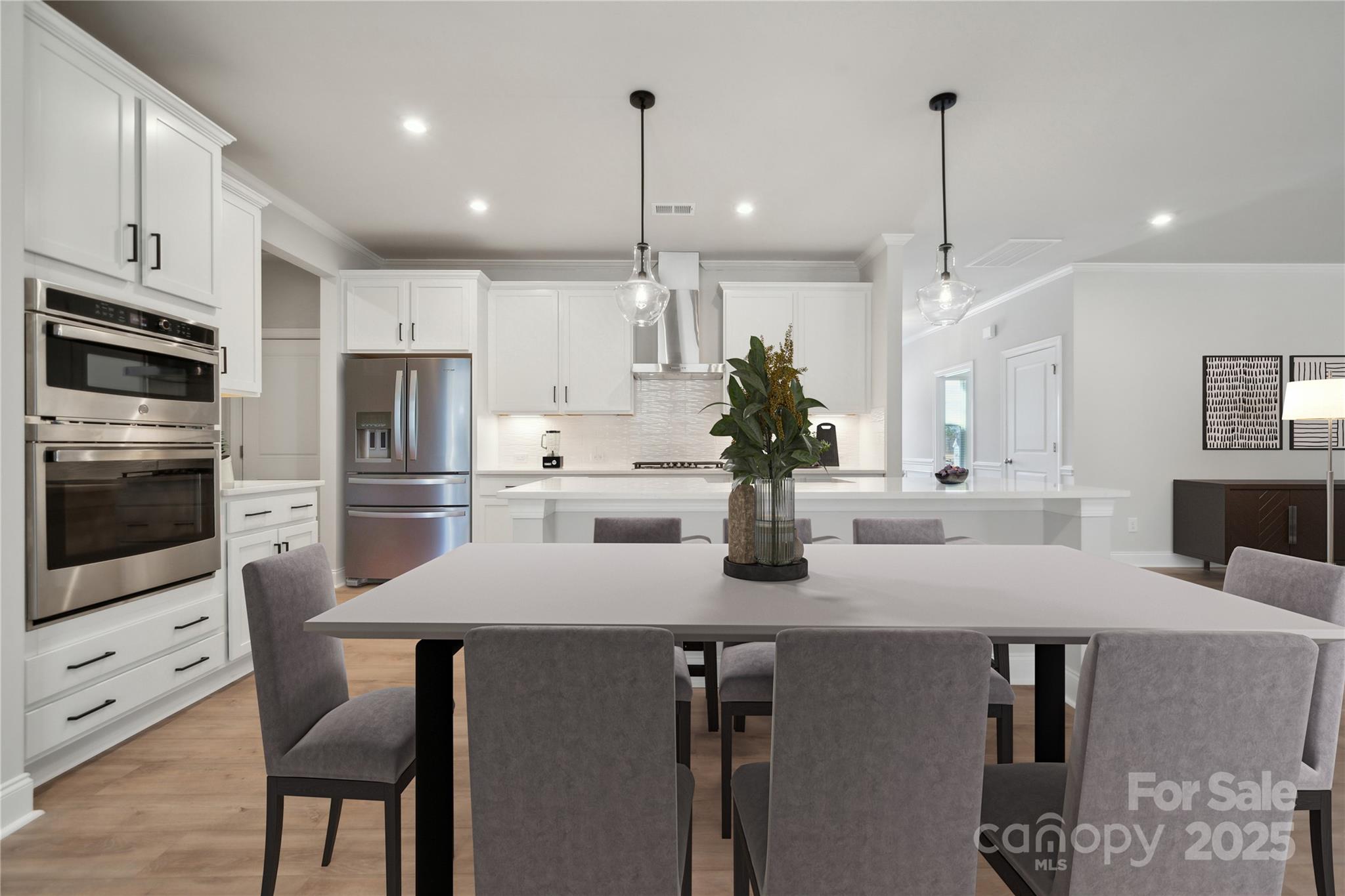 327 Alameda Way Matthews, NC 28104 - Photo 9 of 31 a kitchen with stainless steel appliances granite countertop a sink a stove a refrigerator and a dining table with wooden floor