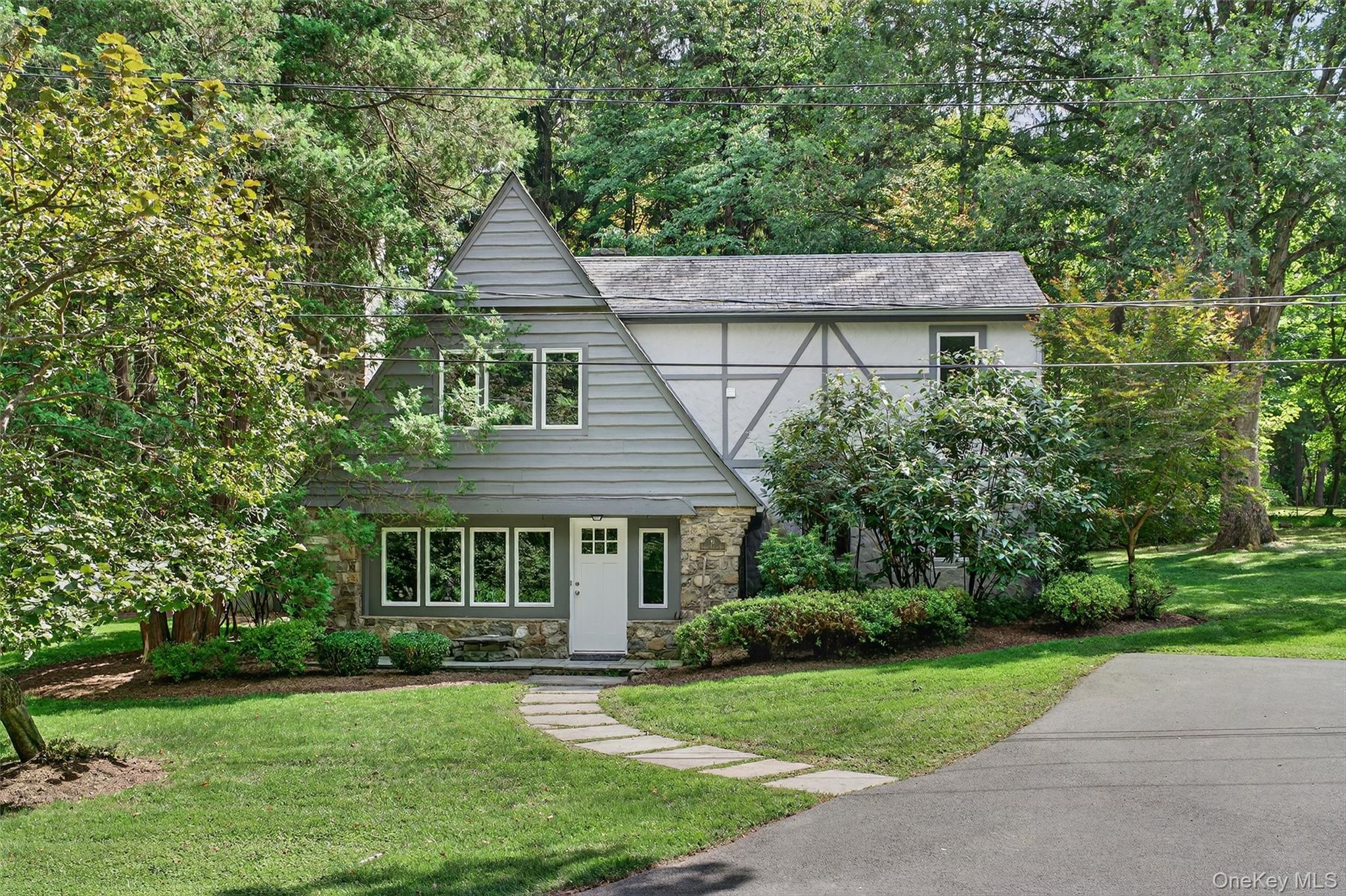 a front view of a house with a yard and trees
