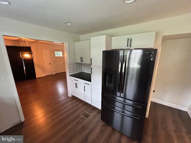a kitchen with stainless steel appliances a refrigerator and wooden floor