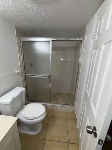 a white toilet sitting next to a shower