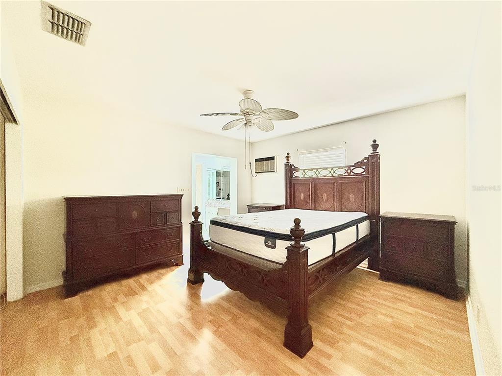 210 14th Avenue Southwest Largo, FL 33770 - Photo 6 of 8 a spacious bedroom with a bed and a dresser