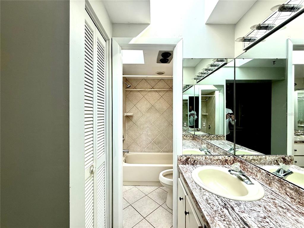 210 14th Avenue Southwest Largo, FL 33770 - Photo 8 of 8 a bathroom with a granite countertop sink and a mirror