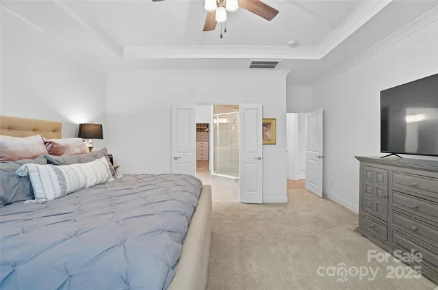 a spacious bedroom with a bed and a chandelier