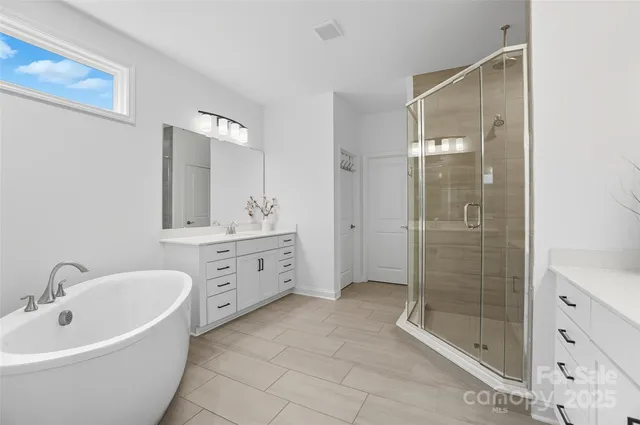 a bathroom with a bathtub sink mirror and shower