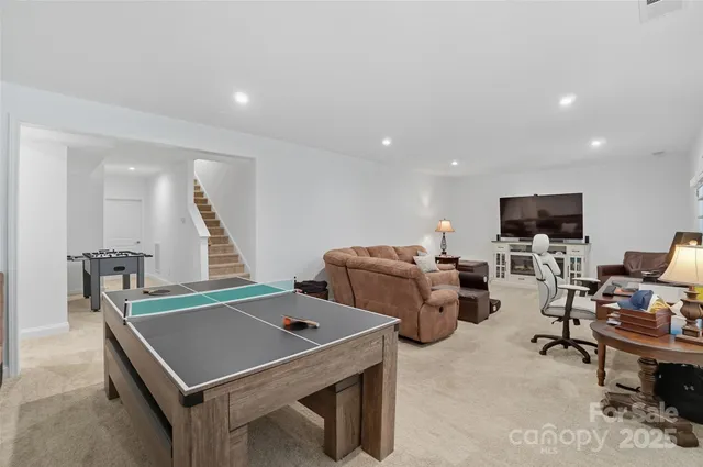 a room with furniture pool table and flat screen tv