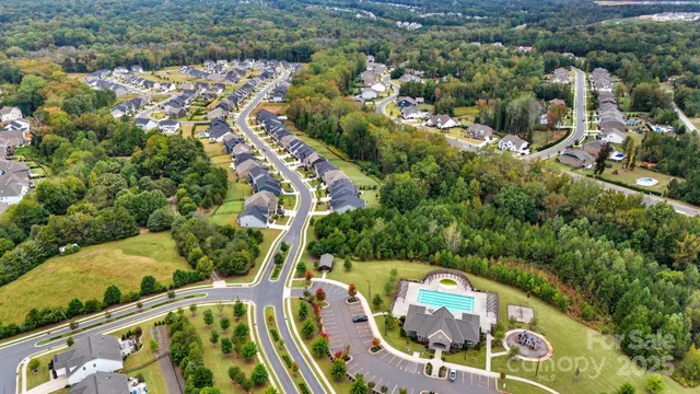 an aerial view of a house with swimming pool and outdoor seating