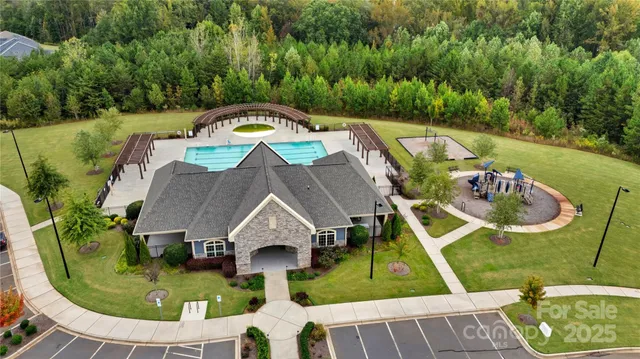 an aerial view of a house with swimming pool and big yard