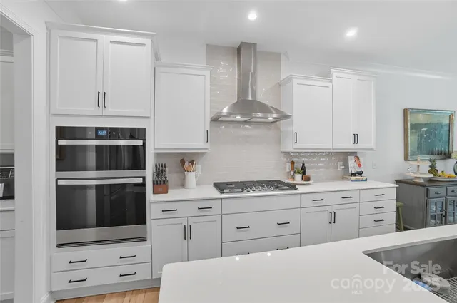 a kitchen with granite countertop white cabinets and stainless steel appliances