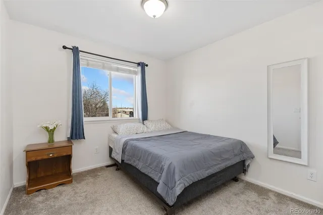 a bedroom with a bed lamp and a window