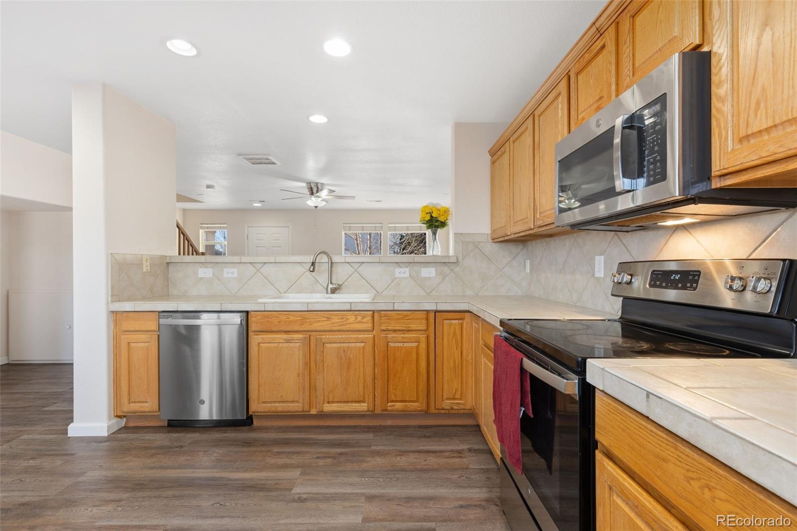 10696 Upper Ridge Road Longmont, CO 80504 - Photo 7 of 25 a kitchen with stainless steel appliances granite countertop a sink a stove and a wooden cabinets