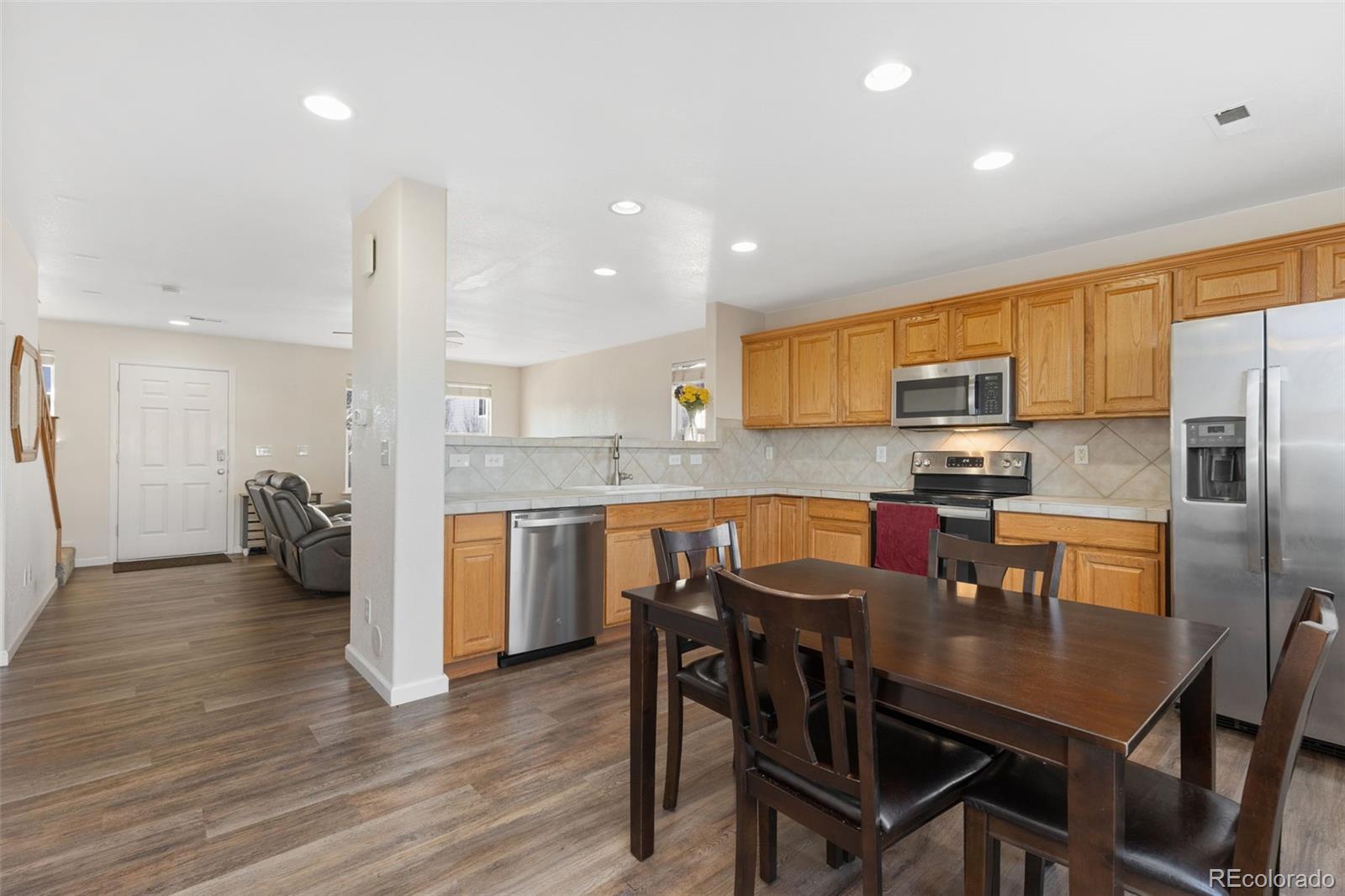 10696 Upper Ridge Road Longmont, CO 80504 - Photo 8 of 25 a kitchen with refrigerator a sink and chairs